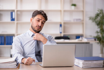 Fototapeta premium Young male employee working in the office