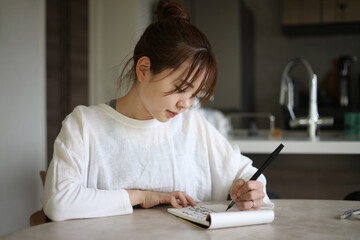 	筆ペンで字を書く女性