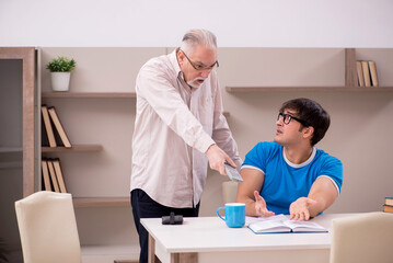 Young male student and his grandfather at home