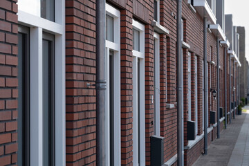 Row of modern new-build social rental homes with red brick walls in Lemmer, the Netherlands. Narrow depth of field