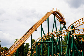 close-up image of a rollercoaster track and the cloudy sky.