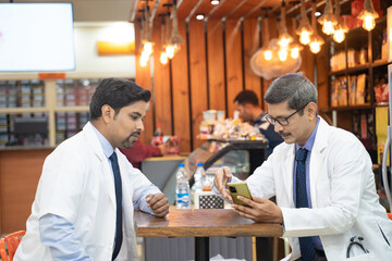 Fototapeta na wymiar Two indian doctors sitting hospital canteen and discussing
