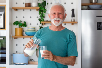 Senior man drinking a glass of milk with a happy face standing and smiling. Handsome senior man...