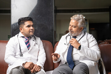 Indian Senior doctor talking with junior doctor.