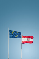 Cover page with two flags of EU and Austria standing in wind together at blue sky gradient background with copy space