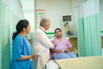 Obraz premium Doctor check up to patient at hospital and asking to female assistant writing some medicine