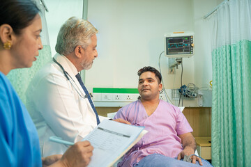 Doctor check up to patient at hospital and asking to female assistant writing some medicine