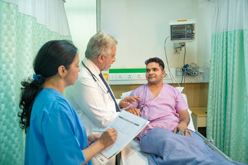 Doctor check up to patient at hospital and asking to female assistant writing some medicine