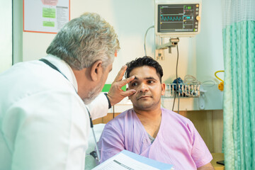 Doctor checking patient eye in medical examination at hospital.