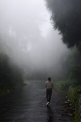 Woman walking on the mountain in fog