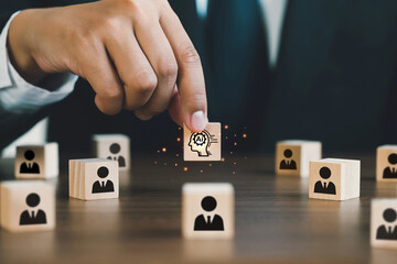  Businessman picked up a wooden block with an Ai icon, surrounded by wooden blocks with a human...