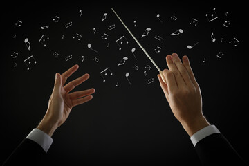Conductor with baton and music notes on dark background, closeup