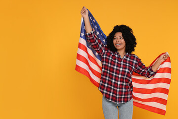 4th of July - Independence Day of USA. Happy woman with American flag on yellow background, space...