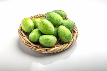 Studio shot raw mangoes kept in bamboo basket on a white background 