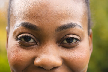 Portrait close up of eyes of happy african american woman in garden smiling