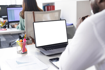 Busy african american casual businessman using laptop with copy space in office
