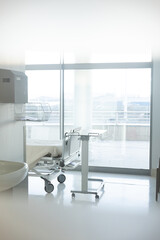 View through door window of patient room with bed and medical equipment at hospital