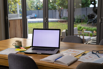 Laptop with copy space on screen on table in dining room