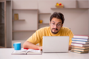 Young male student preparing for exams at home