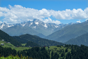 Highland landscape in cloudy and foggy weather. Highland houses made of stone and wood. Wooden plateau houses built on the hill. Wooden plateau houses in Turkey. Pokut Plateau Rize Türkiye.