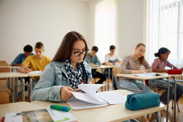 Female high school student learning on class in classroom.