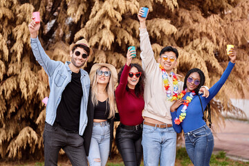 Happy group of multi-ethnic friends having fun while partying at an outdoor carnival. Party, carnival and friendship concept.