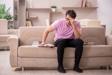 Obraz premium Young male student preparing for exams at home