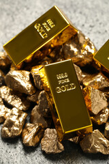 Gold ingots and nuggets on light grey table
