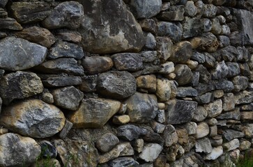 Fototapeta na wymiar Wall made of different stones as background, closeup
