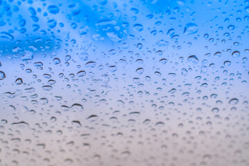 Blissful Rain: Raindrops on the Window with a Blue Tone