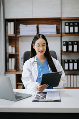Asian smiling doctor or consultant sitting at a desk his neck looking at the camera