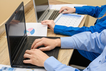 Dwie osoby siedzące przy biurku, piszące na komputerze