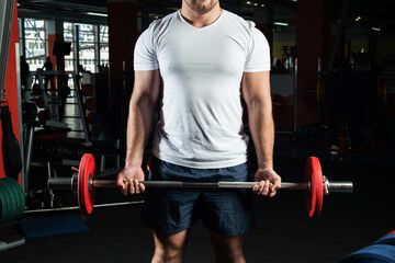 Male athlete lifts the barbell