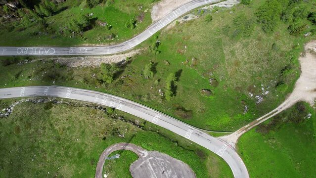 Aerial of painted cyclist names on Passo Giau as car drives by, Giro d'Itlaia
