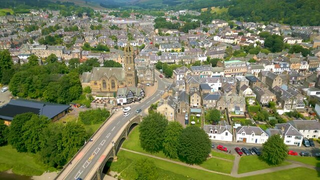 Aerial Drone shot flying from the Tweed Bridge towards Peebles Old Parish Church in the town of Peebles n the Scottish Borders.