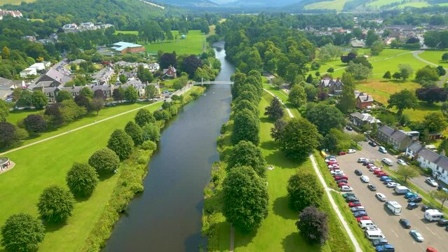 Aerial Drone shot overflying the River Tweed at Peebles in the Scottish Borders heading southeast towards Priorsford Bridge.