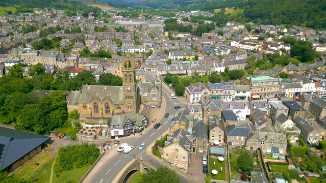 Aerial Drone shot of the town of Peebles in the Scottish Borders pulling back from Peebles Old Parish Church towards the Tweed Bridge.