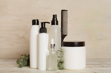 Professional hair care products with comb on wooden background