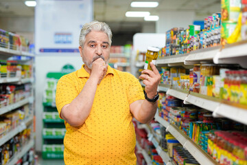 Senior indian man shocking expression on inflation at grocery shop.