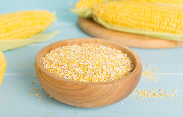 Corn groats with fresh cobs on wooden table