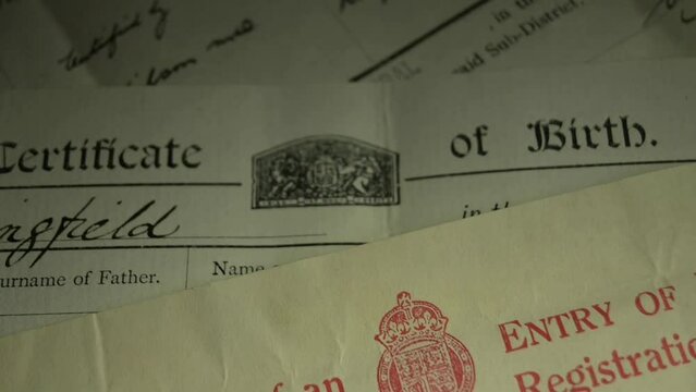 Slow panning shot of Genealogy documents - British birth, marriage and death certificates