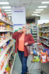 senior indian woman purchasing at grocery shop.