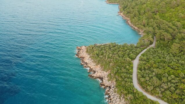 aerial drone footage of beautiful scenic landscape of Marmaris peninsula, mountains and hills with green woods and curved road to Datca destination. peninsula surrounded Aegian and Mediterranean seas.