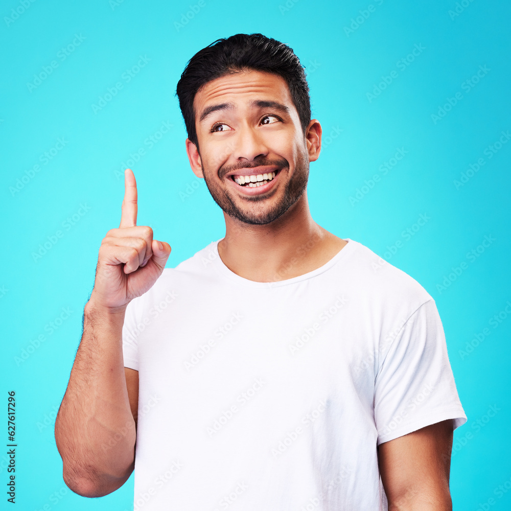 Poster mockup, pointing up and man with a smile, thinking and solution against a blue studio background. ma