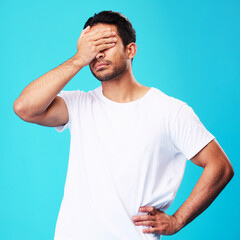 Man, face palm and mistake in studio with thinking, regret and anxiety for fail by blue background....