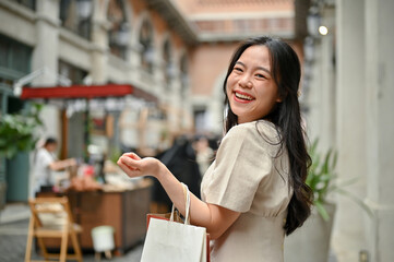 A happy Asian female with her shopping bags enjoying her shopping day in the city.