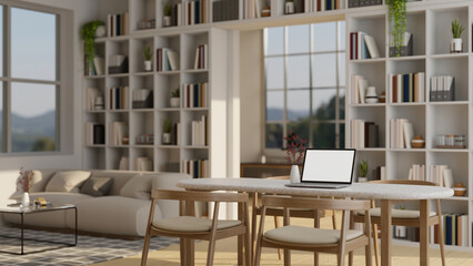 A cozy beautiful living room with a laptop mockup on a dining table, a couch, bookshelves