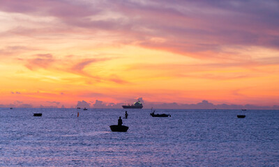 Beautiful colorful sunrise telephoto seascape, with ship silhouettes and colorful cloudy sky.  Sunrise and sunset on the sea.