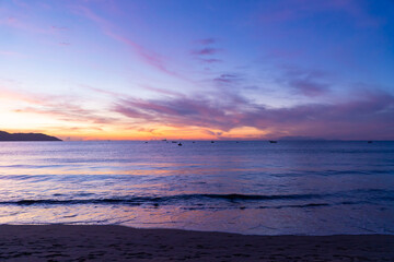Naklejka na ściany i meble Seascape at dawn with boats and colorful sky.