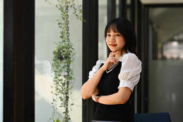 Fototapeta premium Portrait of Asian university female students standing near window and smiling at camera